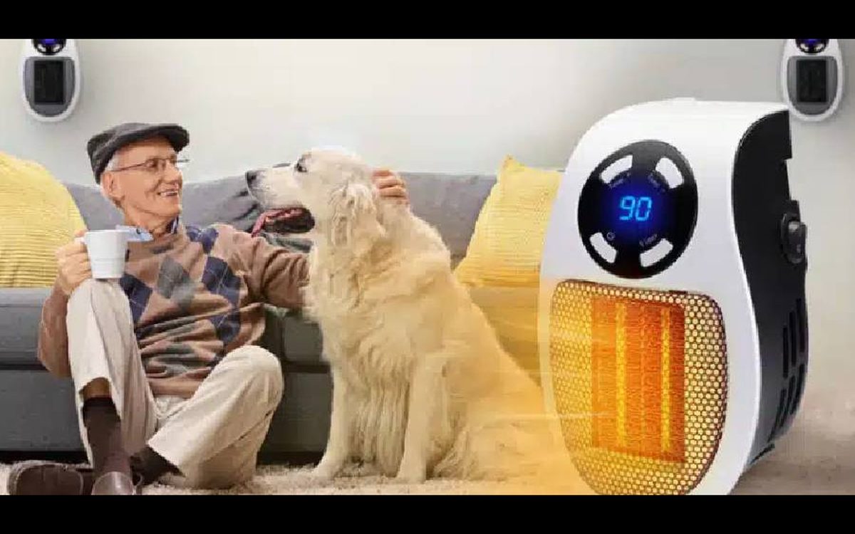 Older man sitting on the floor with his golden retriever next to a small space heater